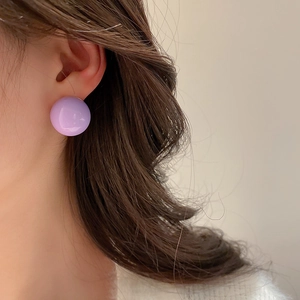 Close-up of elegant lavender purple round bead stud earring worn by a model