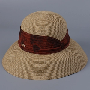 Detailed view of the fine spiral weave texture and reddish-brown fabric band on straw hat
