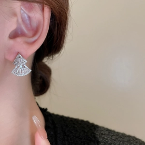 Close-up of elegant double-layered fan-shaped zircon stud earrings worn by a model