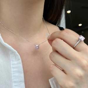 Detail of pink princess-cut gemstone necklace and matching ring on elegant model