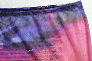 Close-up of the sheer purple and pink mesh fabric with fine stitching and printed pattern