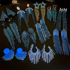 Detailed close-up of geometric tassel earrings with blue rhinestones and gold alloy