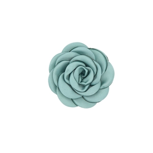 Detail of teal blue satin camellia flower brooch showing silk texture for clothing