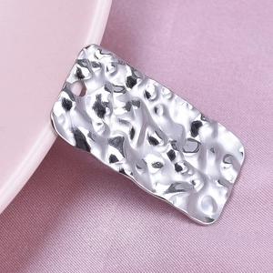 Macro detail of silver rectangle pendant featuring a hammered water ripple texture finish