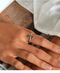 Detailed close-up of s925 silver dragonfly ring with blue enamel wings on finger