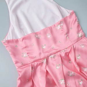 Detail of pink floral satin fabric showing rose prints and pleated waist design