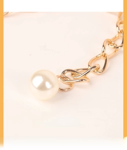 Close-up of gold link chain waist belt with a large elegant faux pearl pendant