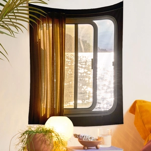 Detail view of sunset window scenery tapestry with warm lighting and home decor elements