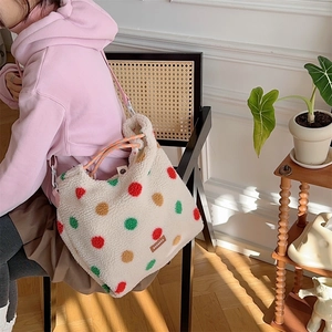 Detail of plush polka dot shoulder bag showing soft fuzzy texture and woven handle