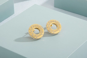Detailed macro view of gold plated hoop earrings with MOM engraving and crystals