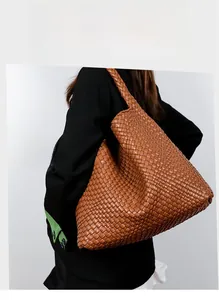 Detail view of caramel brown hand-woven leather tote bag showing intricate craftsmanship