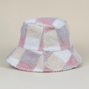 Gros plan détaillé sur la texture en fausse fourrure à carreaux rose et beige du bob