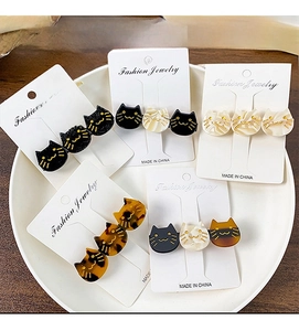Detailed overhead shot of acetate cat-shaped hair clips in various glittery patterns