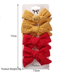 Set of four fabric bow hair clips for kids in red and yellow on a display card