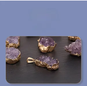 Close-up of raw irregular druzy amethyst pendants with elegant gold plated edges