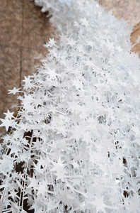 Detailed view of white star-shaped Christmas tinsel garland for festive DIY decorations