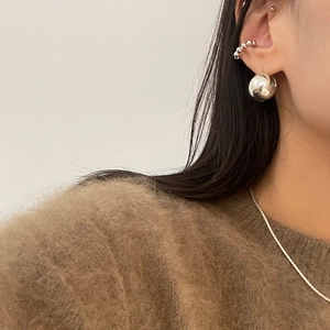 Macro view of S925 sterling silver sphere earrings and ear cuff on a model ear