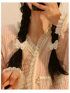 Detail of white mesh butterfly hair clips with pearls on a braided hairstyle