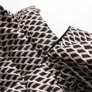Detailed close-up of quilted ski jacket zipper and geometric diamond pattern texture