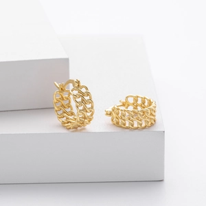 Detailed macro view of gold-plated S925 sterling silver chain link hoop earrings on white blocks