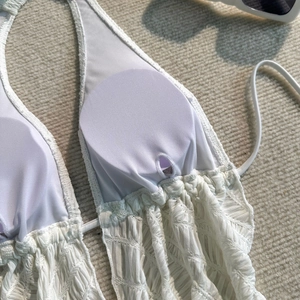 Detail der weißen Bikini-Stofftextur mit herausnehmbaren Brustpolstern und Falten