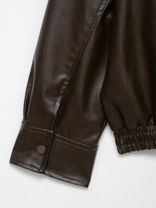 Detailed macro view of dark brown faux leather jacket cuffs and elastic hem stitching