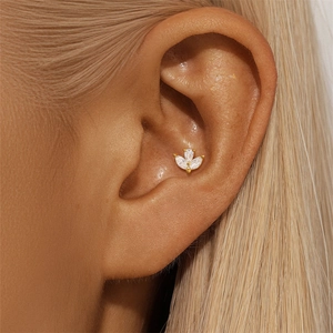 Macro view of gold S925 silver clover piercing stud with white marquise gems on the ear