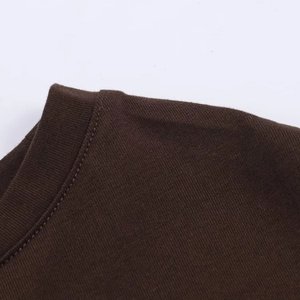 Detail view of high-quality stitching on dark brown knitted fabric dress