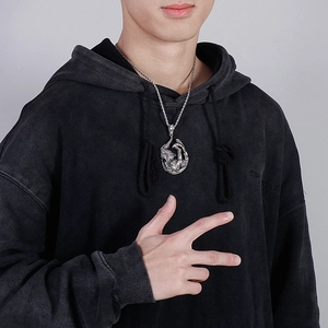 Detail of silver dragon pendant necklace with vintage finish on a male model