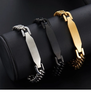 Detailed display of silver, black and gold Cuban link bracelets on a black leather cylinder