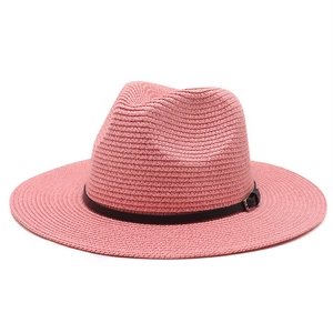 Detailed close-up of pink straw fedora featuring a black leather band with metal buckle