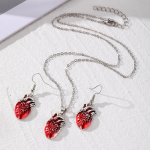 Detailed view of gothic anatomical heart pendant necklace and matching silver drop earrings