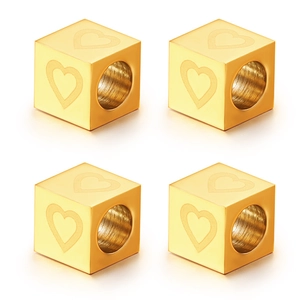 Detailed view of four golden heart-engraved stainless steel cube beads for jewelry DIY