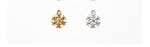 Detail of silver and gold snowflake pendants with inlaid rhinestones on white background