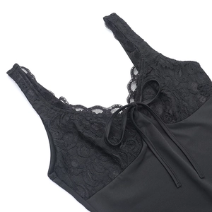 Détail d'une robe en dentelle noire avec un nœud délicat et une texture de tissu lisse
