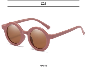 Detail view of round retro children's sunglasses in matte pink C21 with brown lenses