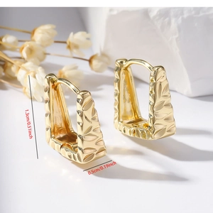 Detail of gold geometric trapezoid earrings with leaf engraving and 1.3cm size markings