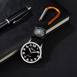 Detail of quartz clip-on fob watch with compass and orange carabiner on black desk