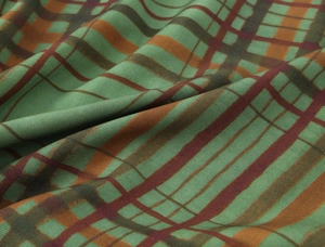 Close-up detail of green plaid twill fabric with textured weave and natural drape