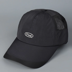 Detail of black quick-dry baseball cap featuring Mad embroidery and breathable mesh panels