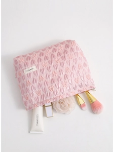 Pink canvas cosmetic bag with 3D heart texture and makeup accessories on white background