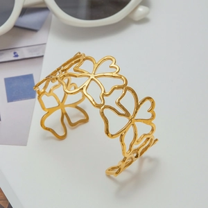 Detail of hollow floral pattern open bangle in 18k gold plated stainless steel