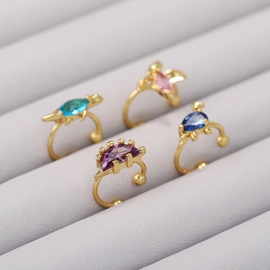 Detailed view of 18K gold dino ear cuffs with colorful purple blue and pink gemstones