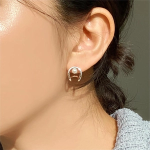 Close-up of S925 sterling silver horseshoe earring with a white pearl on ear
