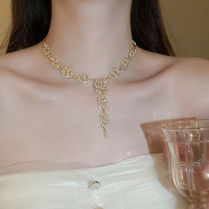 Détail du collier à pampilles de blé doré avec diamants étincelants sur un mannequin