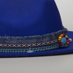 Detail of wool felt hat featuring ethnic woven band, turquoise bead and metal pendant