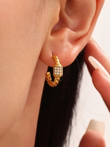 Close-up of 18k gold-plated twisted rope hoop earring with zircon inlay on ear