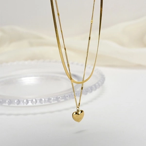 Gold double-layered necklace with engraved heart pendant and sleek snake chain