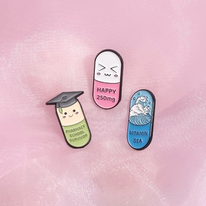 Detail von Emaille-Pins mit Pharmacy School Survivor und Vitamin Sea Kapsel-Designs