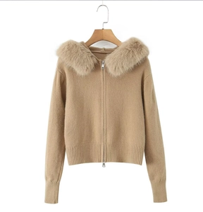 Detail of warm beige knit cardigan featuring a plush faux fur collar and zipper hood